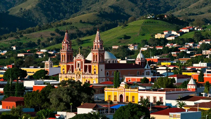 Ciudad mexicana vibrante, arquitectura colorida y valle verde